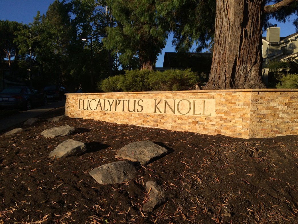 Stacked stone monument entry sign at golden hour